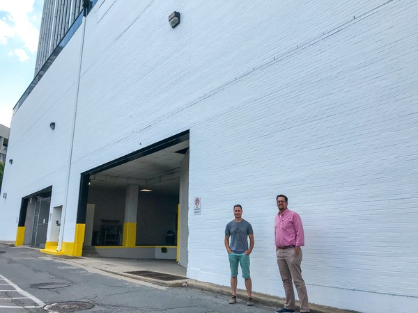 Artist Jason Jones with DLRP Executive Director Gabe Holmstrom standing in front of location of future mural